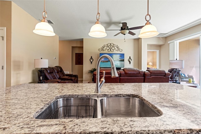 10617 Lucaya Dr, Tampa, FL 33647 - kitchen featuring light stone counters, ceiling fan, open floor plan, and a sink
