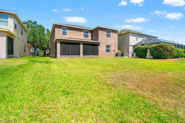 10617 Lucaya Dr, Tampa, FL 33647 - back of property featuring a yard, a sunroom, central AC unit, and stucco siding