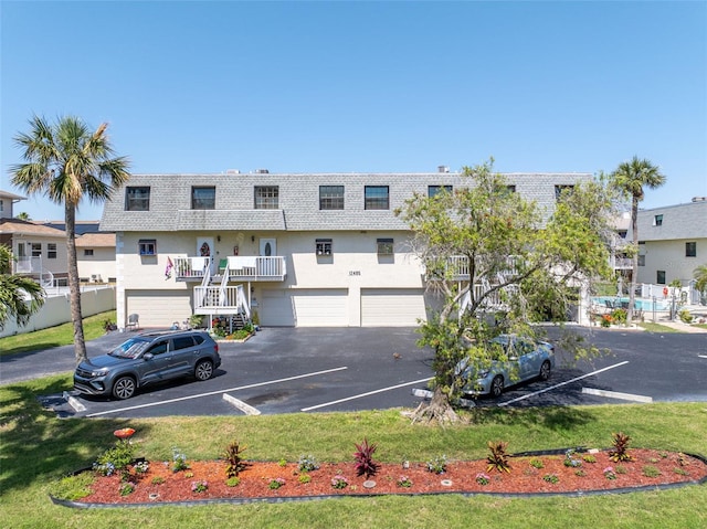 12485 2nd St E Unit C103, Treasure Island, FL 33706 - view of building exterior featuring a garage and stairs