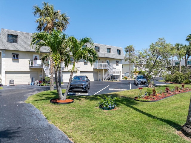 12485 2nd St E Unit C103, Treasure Island, FL 33706 - view of building exterior with stairway and a garage