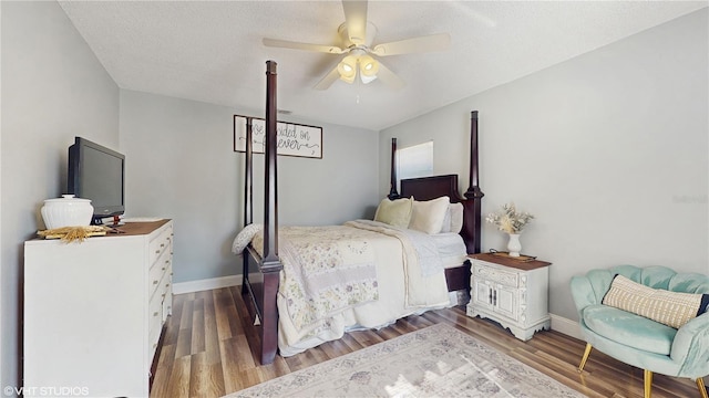 bedroom with a ceiling fan, wood finished floors, and baseboards