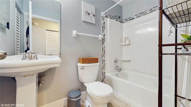 bathroom featuring toilet, tub / shower combination, baseboards, and tile patterned floors