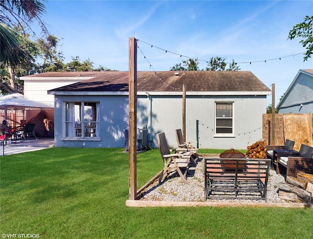 back of property with a gazebo, a patio area, stucco siding, and a fire pit
