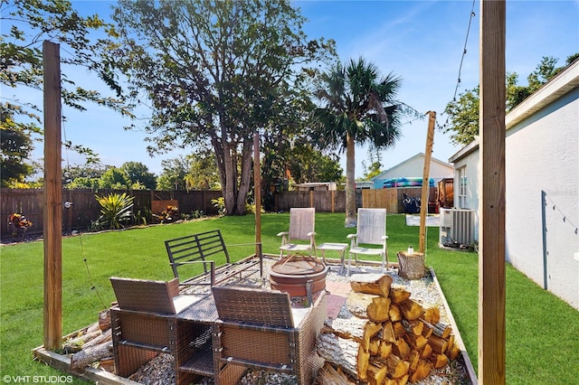 view of patio / terrace with central AC, an outdoor fire pit, and a fenced backyard