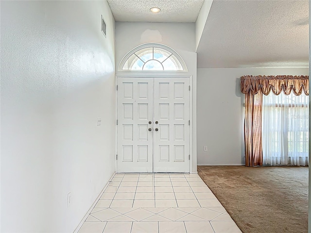11216 Longbrooke Dr, Riverview, FL 33579 - entryway featuring a textured ceiling, plenty of natural light, light carpet, and light tile patterned floors