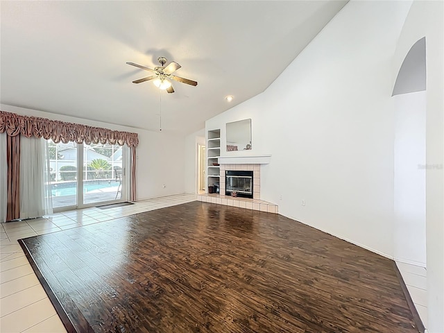11216 Longbrooke Dr, Riverview, FL 33579 - unfurnished living room featuring vaulted ceiling, light wood-style flooring, ceiling fan, built in shelves, and a fireplace