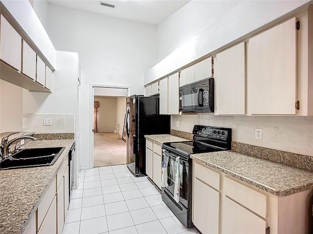 11216 Longbrooke Dr, Riverview, FL 33579 - kitchen featuring black appliances, a sink, a towering ceiling, light tile patterned floors, and light carpet
