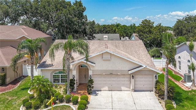 11216 Longbrooke Dr, Riverview, FL 33579 - view of front facade featuring stucco siding, central AC, a shingled roof, an attached garage, and concrete driveway
