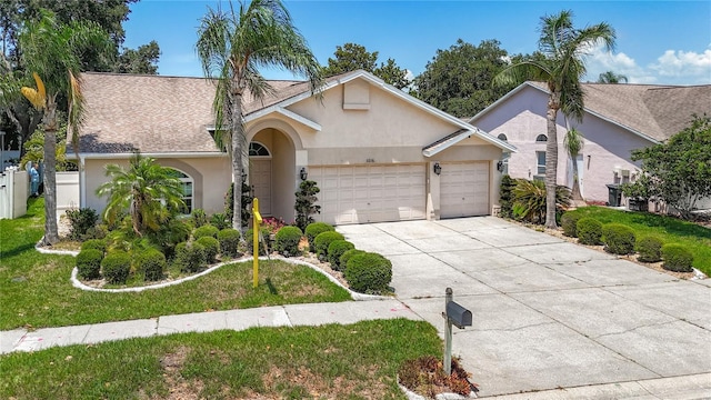 11216 Longbrooke Dr, Riverview, FL 33579 - view of front of home featuring stucco siding, a garage, driveway, a front yard, and a shingled roof