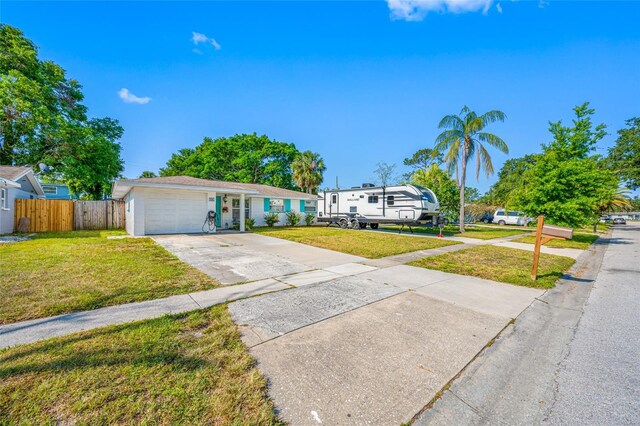 single story home with fence, a garage, a front yard, and concrete driveway