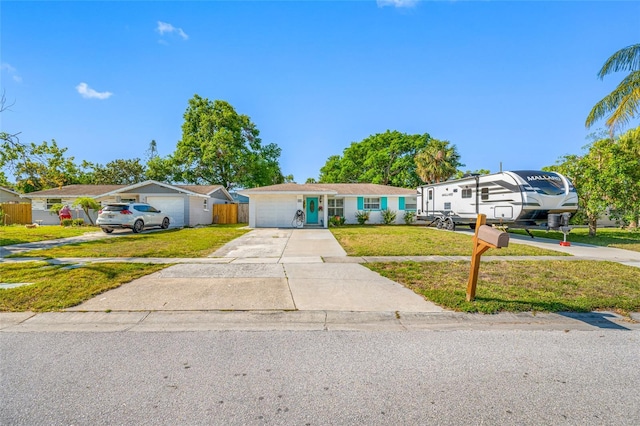 ranch-style home with concrete driveway and a front lawn