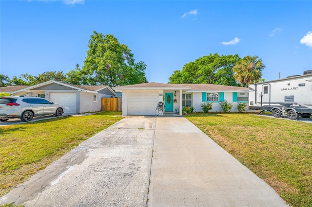 ranch-style house with an attached garage, a front yard, fence, and driveway