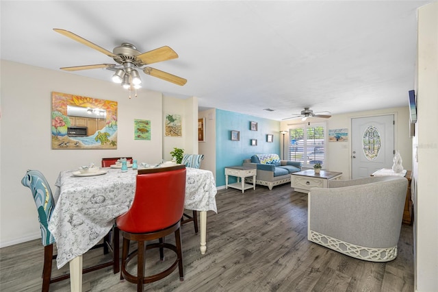 dining room featuring baseboards, a ceiling fan, and wood finished floors