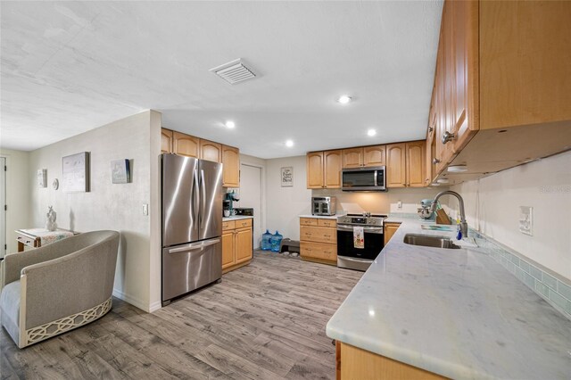 kitchen featuring a sink, light wood finished floors, appliances with stainless steel finishes, visible vents, and recessed lighting