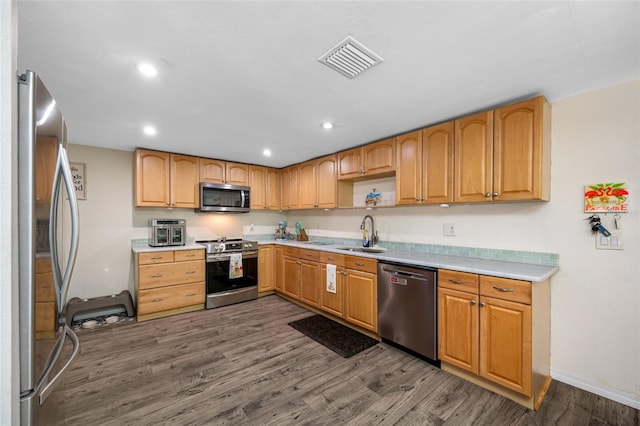 kitchen featuring stainless steel appliances, light countertops, visible vents, a sink, and dark wood-style flooring