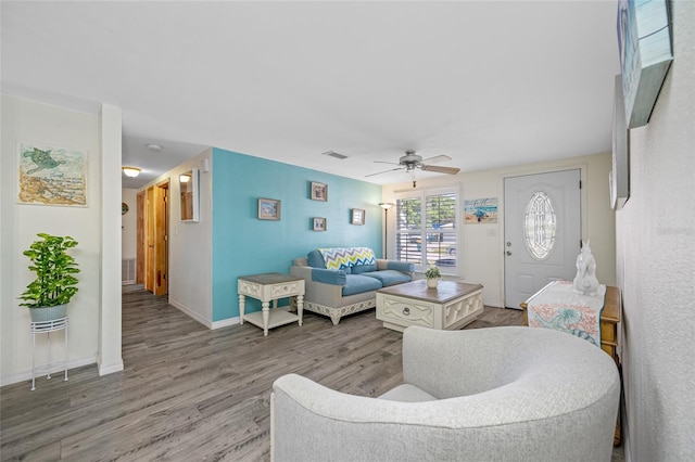 living room with ceiling fan, baseboards, wood finished floors, and visible vents