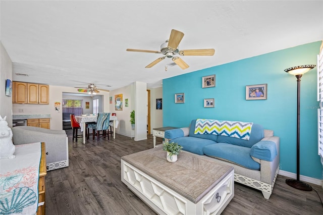 living area featuring dark wood finished floors, visible vents, a ceiling fan, and baseboards