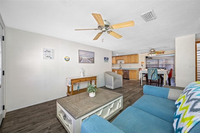 living area with baseboards, a ceiling fan, visible vents, and dark wood finished floors