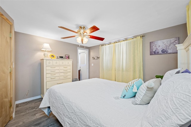 bedroom with wood finished floors, a ceiling fan, and baseboards