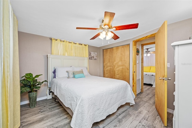 bedroom featuring light wood-style floors, a closet, baseboards, and ceiling fan