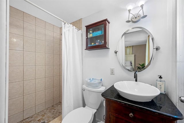 bathroom featuring a tile shower, toilet, and vanity