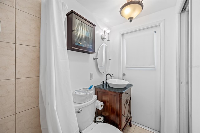 bathroom featuring tile patterned flooring, toilet, vanity, and curtained shower