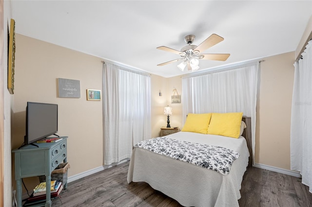 bedroom featuring baseboards, a ceiling fan, and wood finished floors