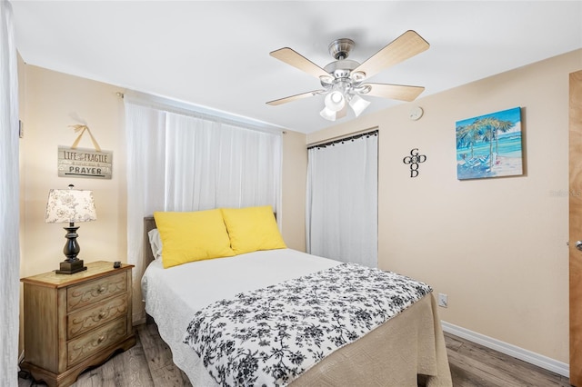 bedroom with wood finished floors, baseboards, and ceiling fan