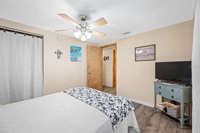 bedroom with wood finished floors, visible vents, a ceiling fan, and baseboards