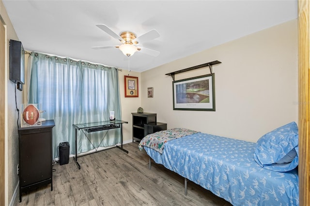 bedroom with baseboards, a ceiling fan, and wood finished floors