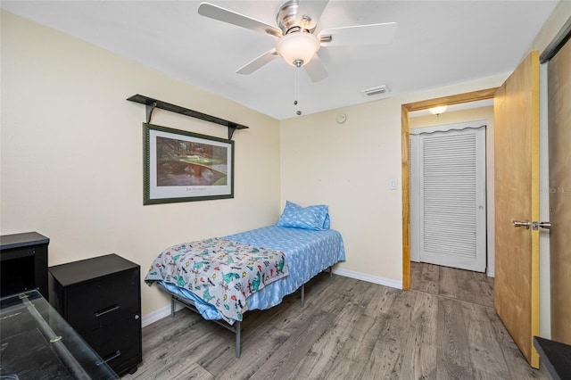 bedroom featuring wood finished floors, baseboards, and ceiling fan
