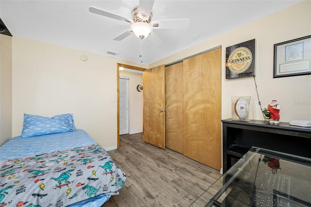 bedroom featuring a closet, ceiling fan, light wood-style flooring, baseboards, and visible vents