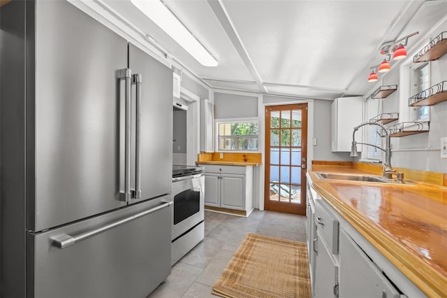 2450 3rd Ave N, Saint Petersburg, FL 33713 - kitchen featuring appliances with stainless steel finishes, open shelves, lofted ceiling, butcher block counters, and white cabinetry
