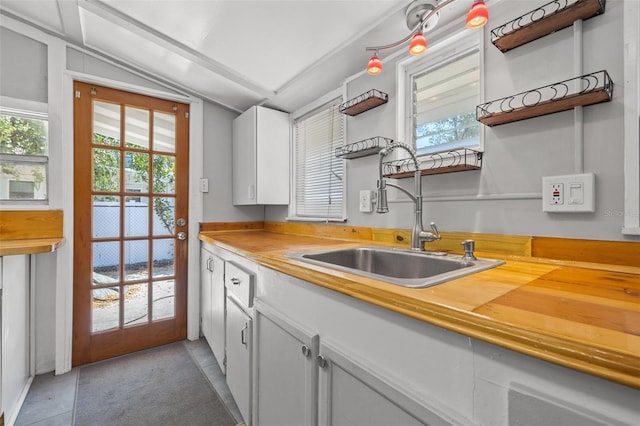 2450 3rd Ave N, Saint Petersburg, FL 33713 - kitchen featuring open shelves, vaulted ceiling, and white cabinets