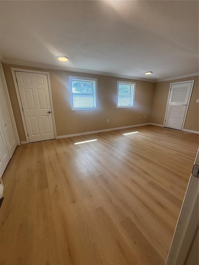 interior space featuring crown molding, light wood-style floors, and baseboards