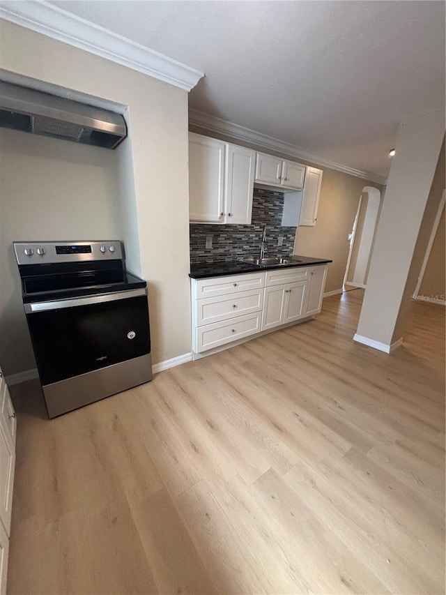 kitchen featuring crown molding, dark countertops, a sink, stainless steel electric stove, and white cabinetry