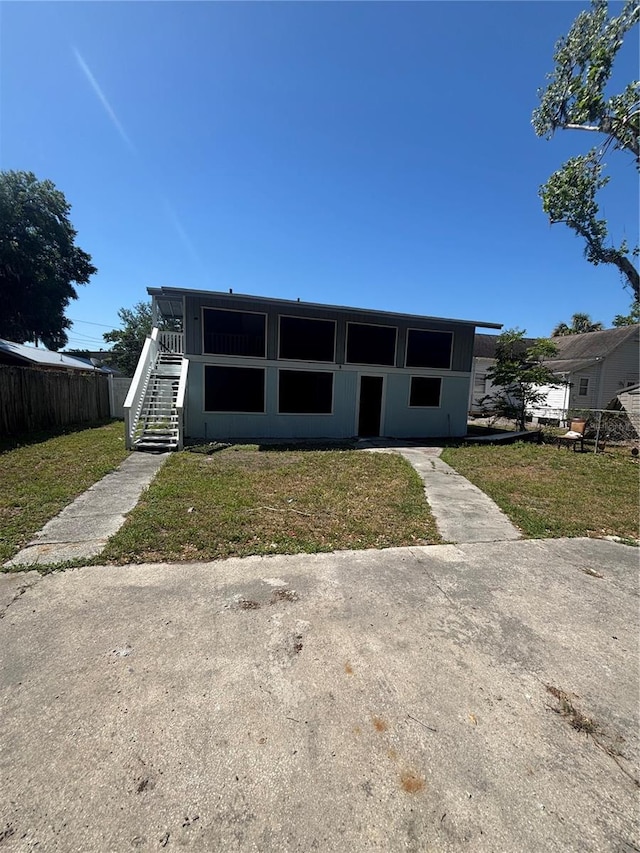 view of front of property with fence, stairs, and a front yard