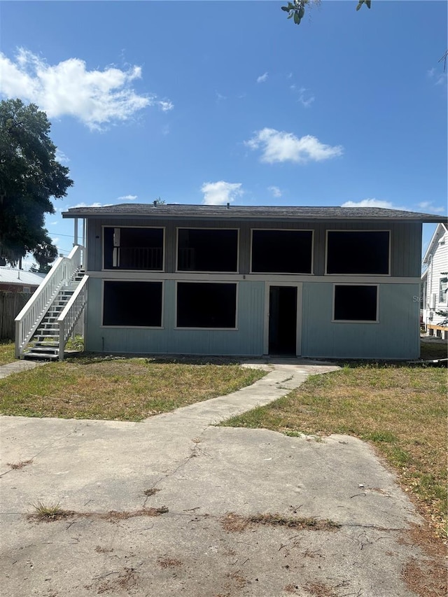 view of front of house featuring a front lawn and stairway