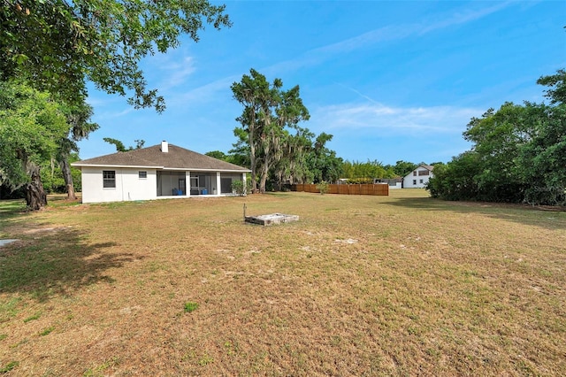 view of yard with a sunroom and fence