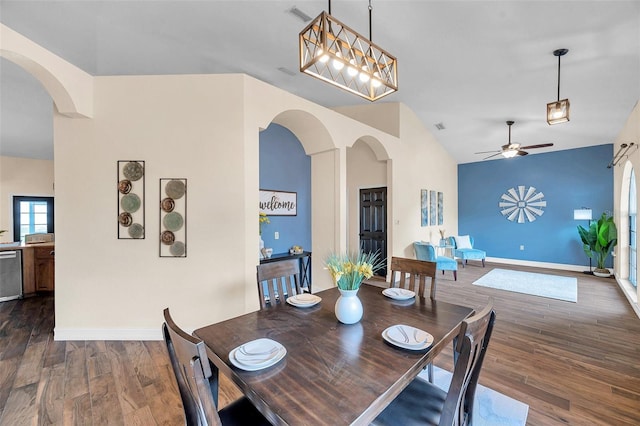 dining room featuring vaulted ceiling, arched walkways, ceiling fan, and dark wood finished floors