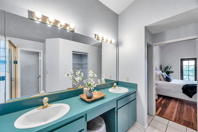 ensuite bathroom featuring ensuite bathroom, a sink, double vanity, and a stall shower