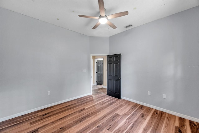 unfurnished room with light wood-style floors, visible vents, baseboards, and ceiling fan