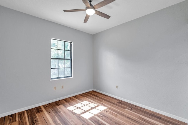 empty room featuring ceiling fan, baseboards, and wood finished floors