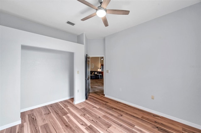 spare room with baseboards, visible vents, light wood-style floors, and ceiling fan