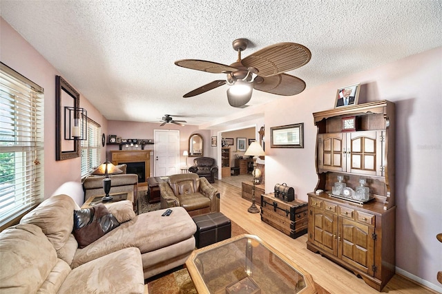 1399 Leeward Ave, Spring Hill, FL 34606 - living area featuring light wood finished floors, a ceiling fan, a textured ceiling, and a fireplace