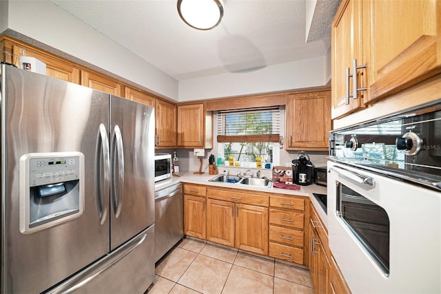 1399 Leeward Ave, Spring Hill, FL 34606 - kitchen featuring light tile patterned flooring, brown cabinets, stainless steel appliances, and a sink