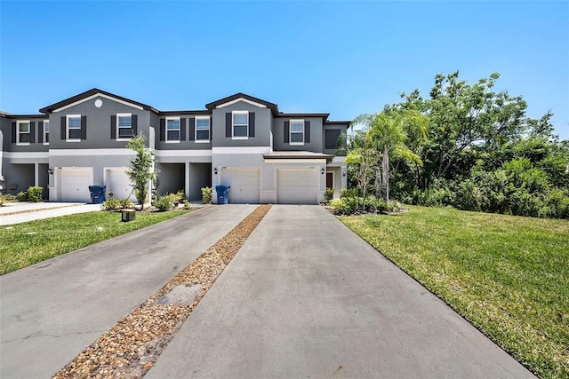 23378 Papyrus Way, Lutz, FL 33549 - townhome / multi-family property featuring an attached garage, a front lawn, driveway, and stucco siding