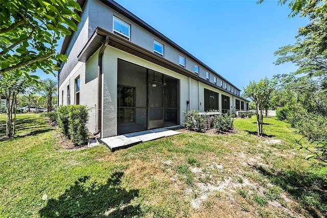 23378 Papyrus Way, Lutz, FL 33549 - back of property featuring a lawn, a sunroom, cooling unit, and stucco siding