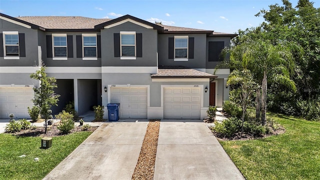 23378 Papyrus Way, Lutz, FL 33549 - townhome / multi-family property with a front lawn, concrete driveway, stucco siding, roof with shingles, and a garage