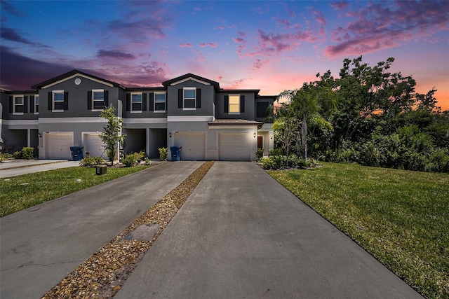 23378 Papyrus Way, Lutz, FL 33549 - townhome / multi-family property with a front lawn, an attached garage, concrete driveway, and stucco siding
